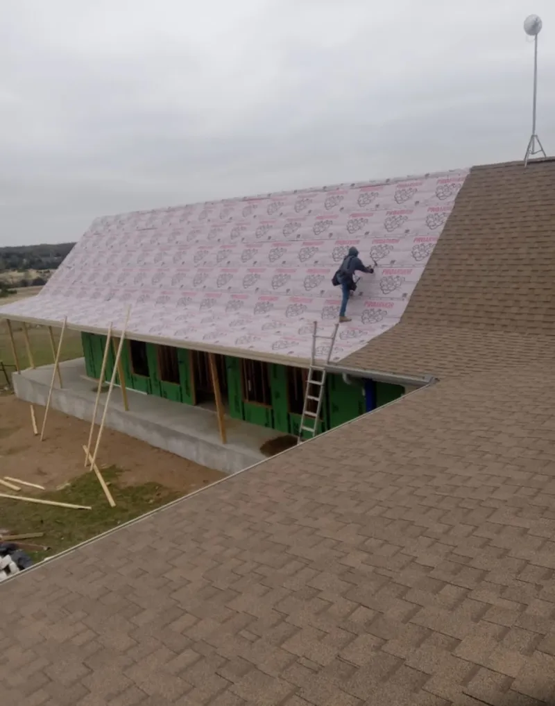 Worker preparing underlayment for a metal roof installation in Bridgeton